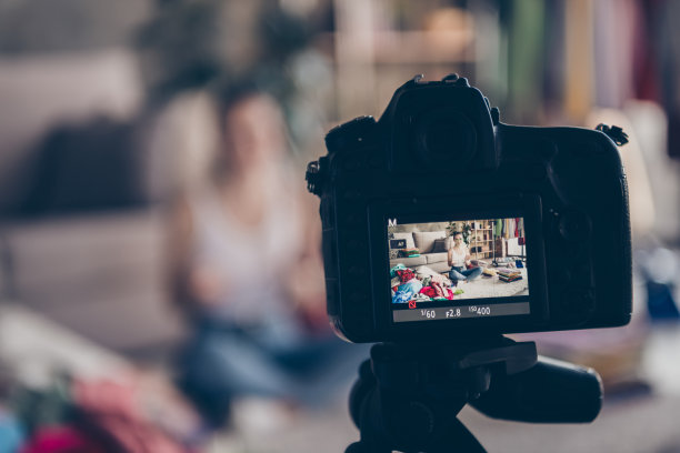 模糊特写照片的女孩博主用相机拍摄商场决定在室内挑选衣服屏幕图片下载