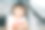 一个穿着粉红色裙子、蓝眼睛的小女孩坐在厨房里，拿着一只粉红色的鸡尾酒杯喝着酒，做着鬼脸图片下载