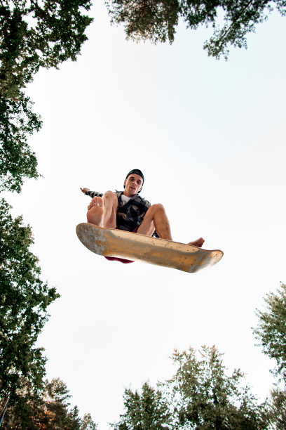 观看运动员与滑板模拟器跳起来的背景天空图片下载