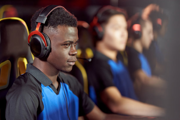 男玩家戴着耳机在游戏俱乐部或网吧里玩电子游戏，参加电子竞技比赛图片下载