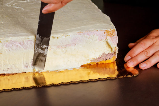 在蛋糕上涂上甜奶油。制作多层海绵蛋糕。图片下载