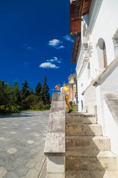 一个小女孩站在一栋大楼的门廊上。图片下载