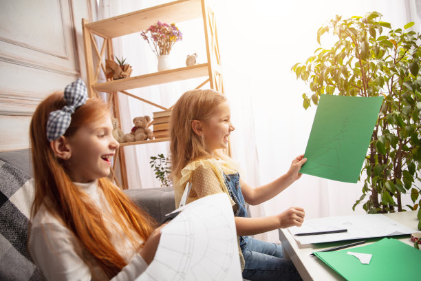两个小孩，女孩一起在创造力的房子。快乐的孩子们为游戏或庆祝新年自制玩具图片下载