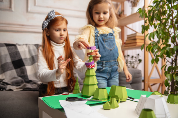 两个小孩，女孩一起在创造力的房子。快乐的孩子们为游戏或庆祝新年自制玩具图片下载
