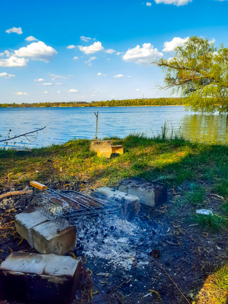 在河边的篝火上用便携式烧烤架烤香肠图片下载