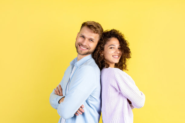 非洲裔美国妇女和欧洲男子站在黄色背景上图片下载