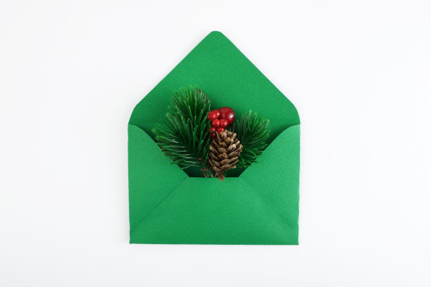 绿色的信封与白色的床单和圣诞树枝孤立在白色的背景。圣诞节邮件。圣诞节或新年祝贺的概念。前视图。平的。本空间图片下载