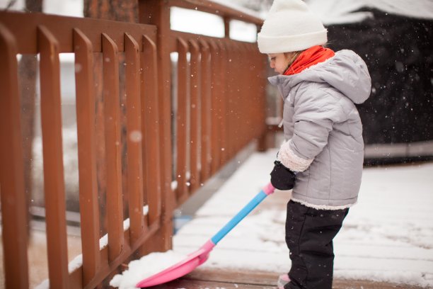 可爱的孩子在冬天的外套铲雪图片下载