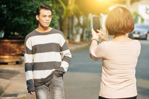 母亲给儿子拍照图片下载