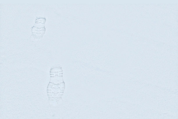 脚印在皑皑白雪中，俯视图。初雪上的新鞋印，复制空间图片下载