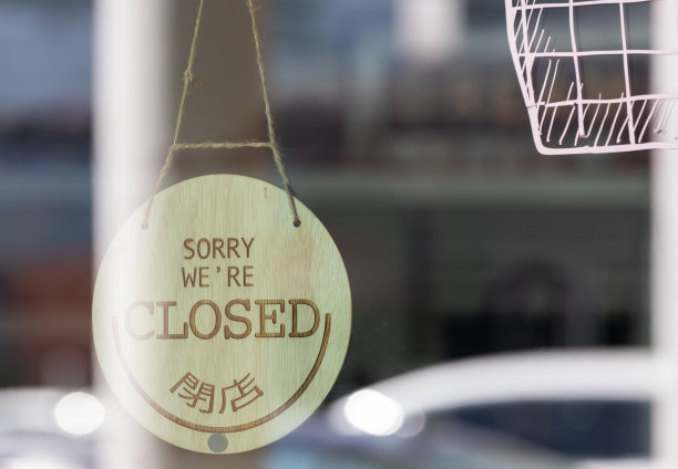 亚洲店的玻璃门上挂着木布告板。对不起，我们快到了。图片下载