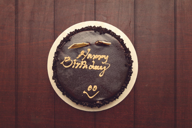 美味的巧克力生日蛋糕放在木桌上图片下载