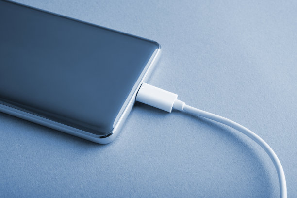 给连接到电源的手机充电。图片下载