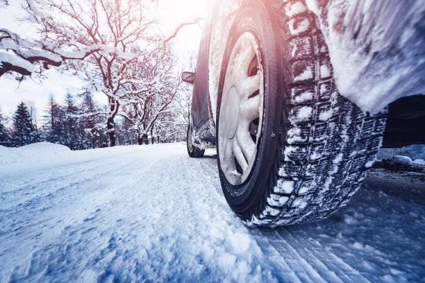 汽车轮胎在被雪覆盖的冬季道路上行驶图片下载