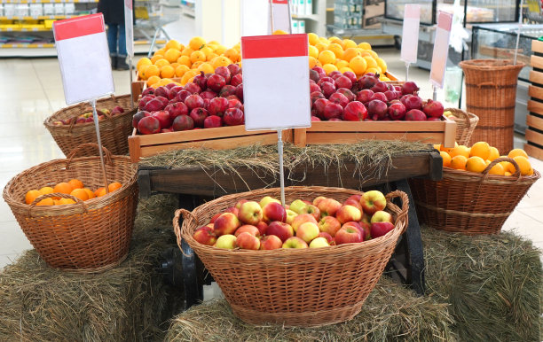 在超市卖水果。橱窗里放着苹果、石榴、橘子和柠檬。所有的水果都装在一个柳条篮子里。空着的白色房间，按你的价格。图片下载