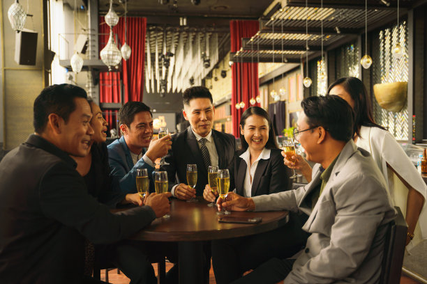 在商务俱乐部和酒廊举行的商务聚会上，亚洲商务人士聚在一起畅饮葡萄酒或香槟，畅谈友谊图片下载