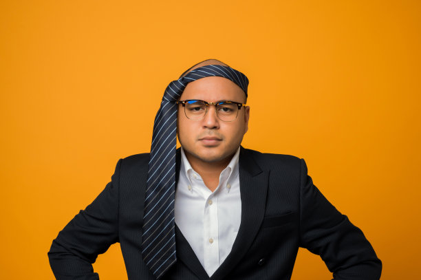 疯狂的商务光头宿醉男子戴着领带，脸上带着严肃的表情孤立在黄色的背景上。图片下载