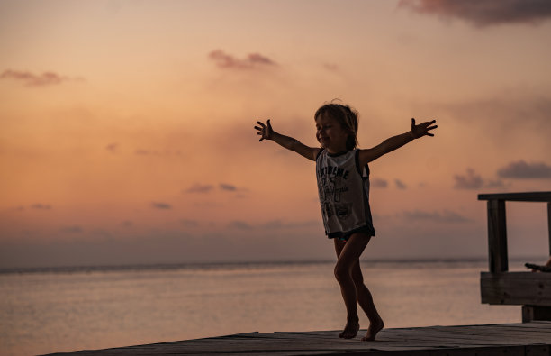 小孩在海滩码头上跑步图片下载