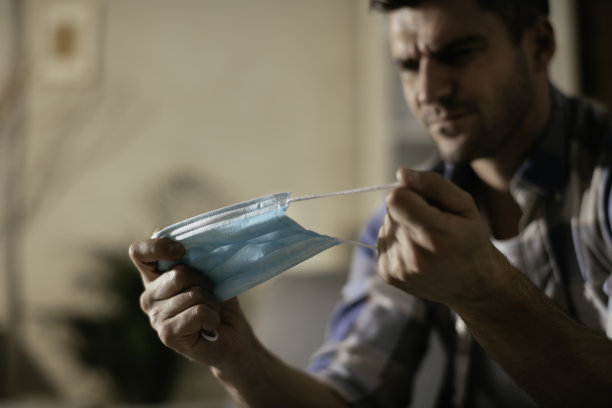 一个焦虑的男人在压力与保护面具库存照片图片下载