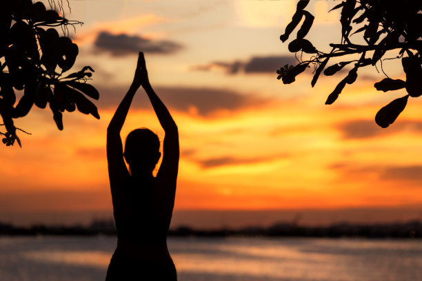 生活方式女性瑜伽锻炼和姿势健康的生活。年轻的女孩或人们摆出平衡身体重要的禅和冥想锻炼剪影日落海滩和大海的背景。健康的概念图片下载