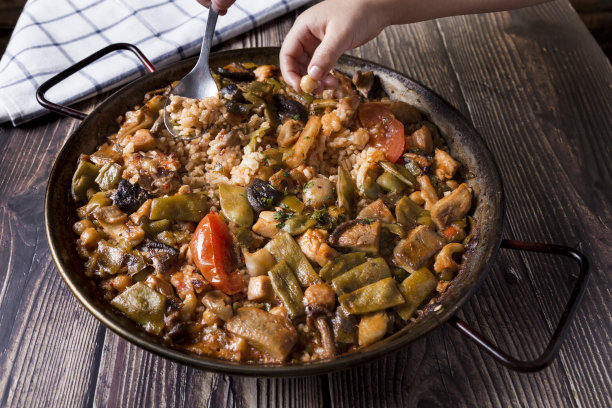 孩子和父亲在吃海鲜饭。手品尝海鲜饭图片下载