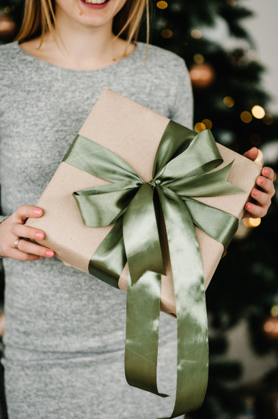 女人手里拿着圣诞礼物或新年装饰的礼品盒。健美的图片。圣诞快乐，节日快乐。关闭了。图片下载