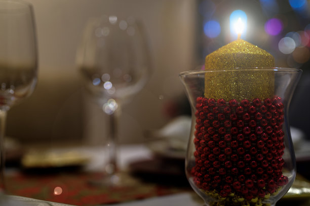 在浪漫的晚餐中，点燃一支装饰性的蜡烛，背景失去焦点图片下载