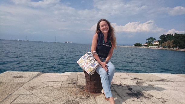 美丽的老女人坐在朋辈上，在海边享受夏日图片下载