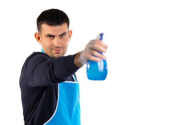 一个戴着橡胶手套、系着围裙的男人看了看，把大腊肠指向了摄像机。性别平等的概念。照片在白色背景与空白的边空间图片下载