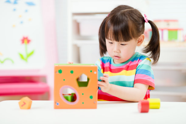 小女孩玩数字形状的玩具积木在家上学图片下载