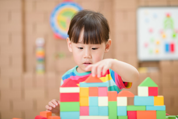 年轻女孩玩创造性玩具积木在家上学图片下载