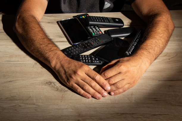 科技上瘾的家伙会保护他的遥控器和智能手机图片下载