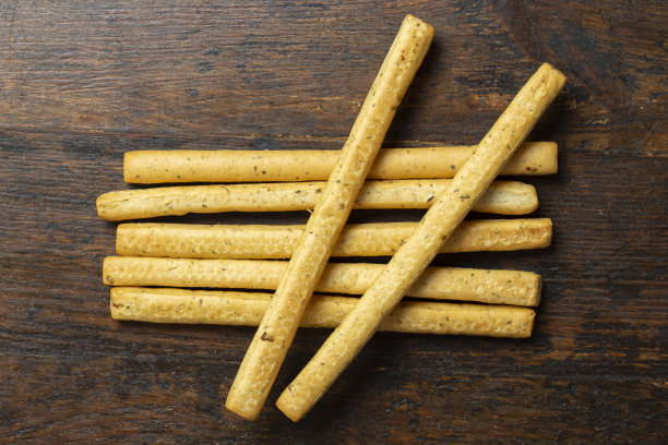 自制的意大利格里森尼面包棒在木材背景上。意大利传统的香草小吃。空间的文本。图片下载