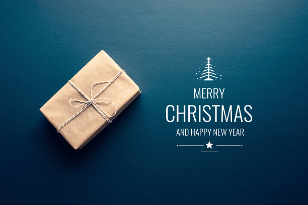 棕色的自制礼盒和圣诞快乐的文字在黑暗的背景图片下载