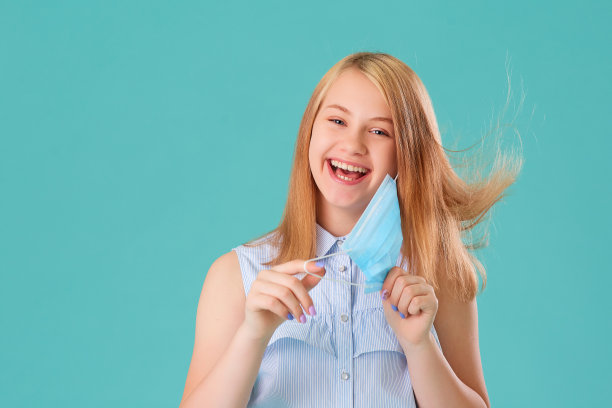 女孩笑了，摘下面具，笑了，心情好。冠状病毒检疫的概念，卫生与医药的主题。医学病毒海报设计。文本的空闲空间。图片下载