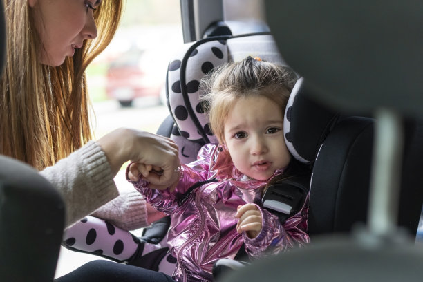 妈妈把孩子放在汽车安全座椅上图片下载