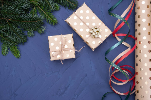蓝色背景的桌子上放着装着礼物和云杉树枝的盒子图片下载