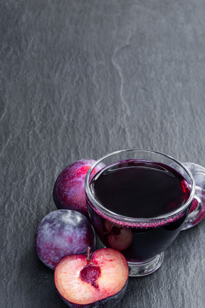 黑石背景上的鲜梅子汁图片下载