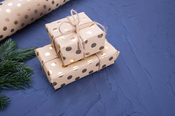 桌上放着装满礼物、包装纸和云杉树枝的盒子图片下载