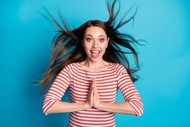 照片的积极，愉快，惊讶的女孩印象深刻的幸运礼物等待了很久，把双手放在一起尖叫，哇哦，我的天穿好看的衬衫孤立的蓝色背景图片下载