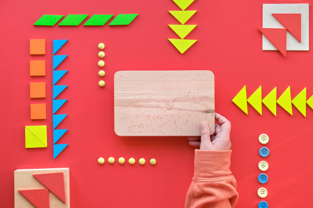 创意设计，世界自闭症日，手拿木板。七边形拼图，平铺在红色上，文字空白图片下载