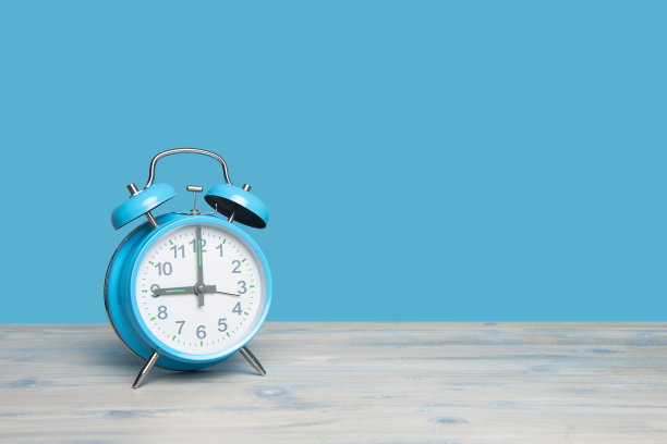 蓝色复古闹钟在9点钟在蓝色背景与空间复制图片下载