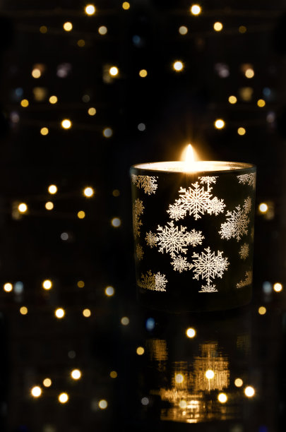 燃烧的圣诞蜡烛和黑色背景的散景图片下载