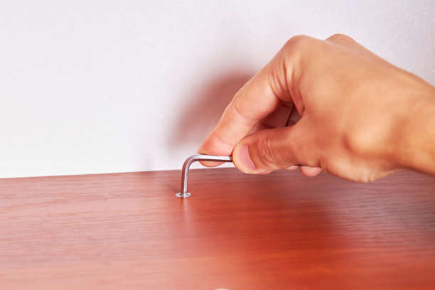 修理工调整木制家具。住房补贴的概念。使用工作工具组装或固定家具的人员。国内的生活。diy的概念图片下载