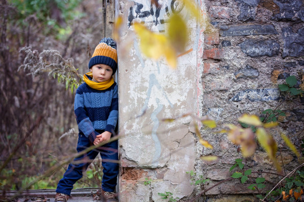 一个孩子，在一个被涂鸦的旧建筑里摆姿势图片下载