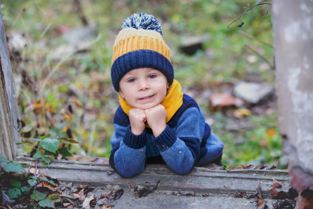 一个孩子，在一座破旧的建筑里摆姿势，脸上涂满了涂鸦图片下载