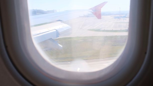 透过飞机窗口看飞机飞行从内部窗口飞机的旅行。着陆图片下载