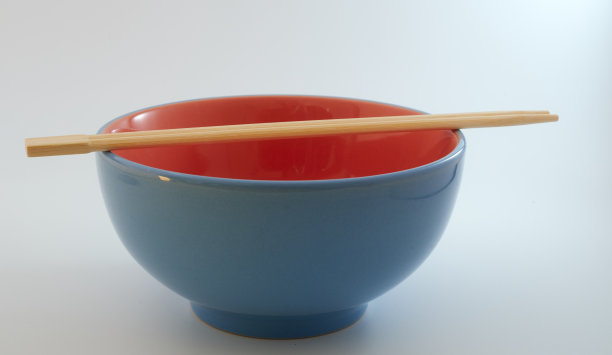 筷子和蓝色的碗孤立在白色的背景图片下载