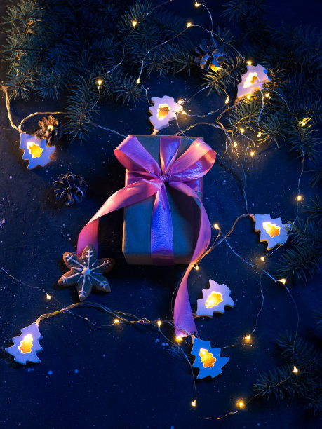 优雅的礼品盒与粉色丝带在圣诞桌上与圣诞树的树枝和一个美丽的花环顶视图图片下载