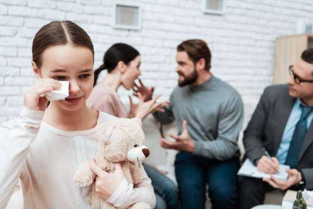 小女孩手里拿着泰迪熊哭了，因为父母在接待处和心理学家吵架。图片下载